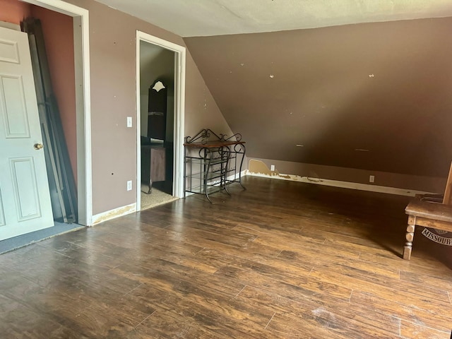 additional living space featuring lofted ceiling and dark hardwood / wood-style flooring