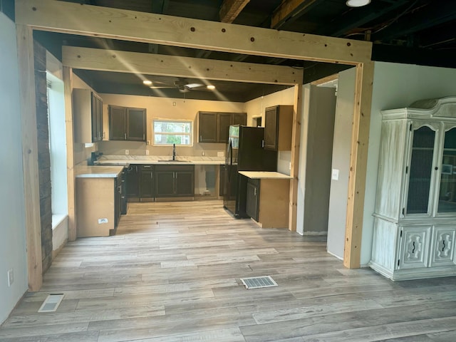 kitchen with sink, light hardwood / wood-style flooring, and black refrigerator