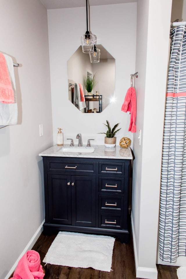 bathroom featuring baseboards, vanity, and wood finished floors