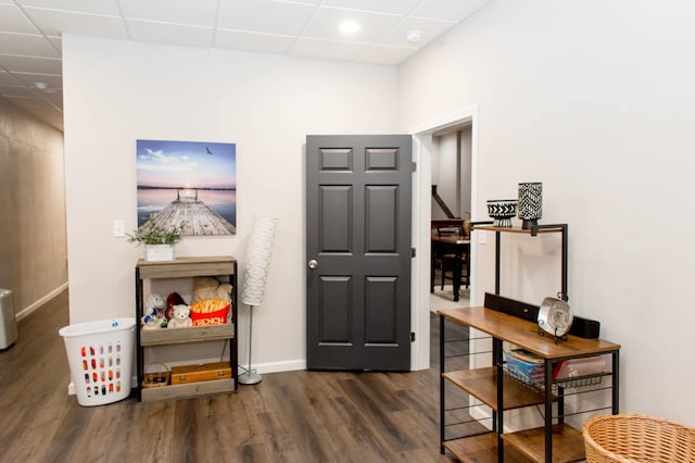entryway with baseboards, a paneled ceiling, and wood finished floors