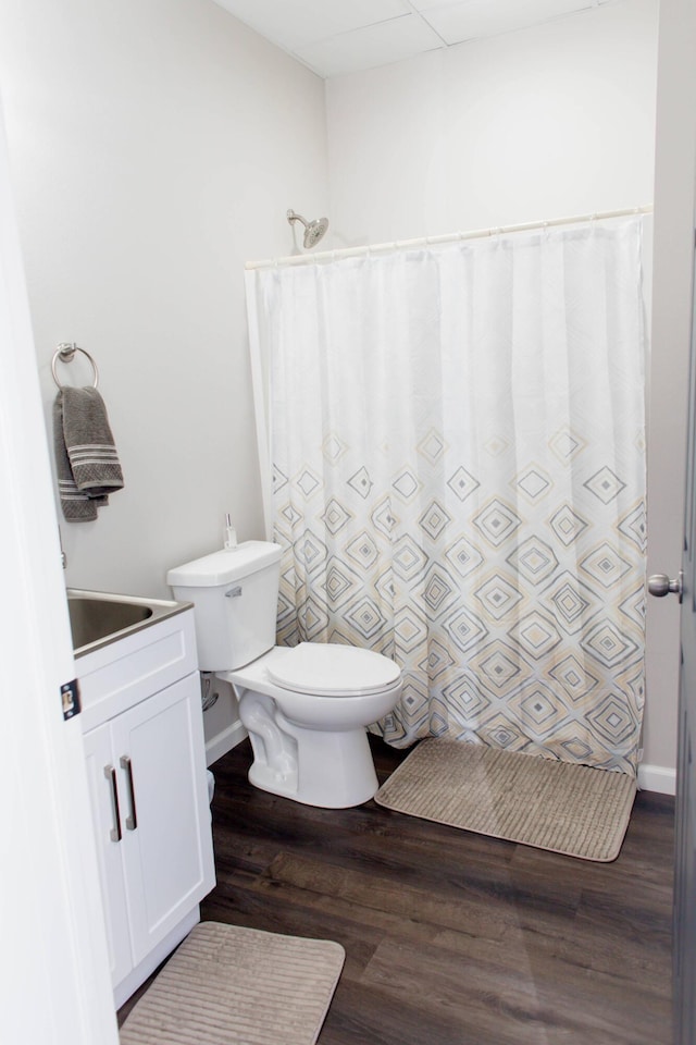 full bathroom with a shower with curtain, wood finished floors, toilet, and a sink