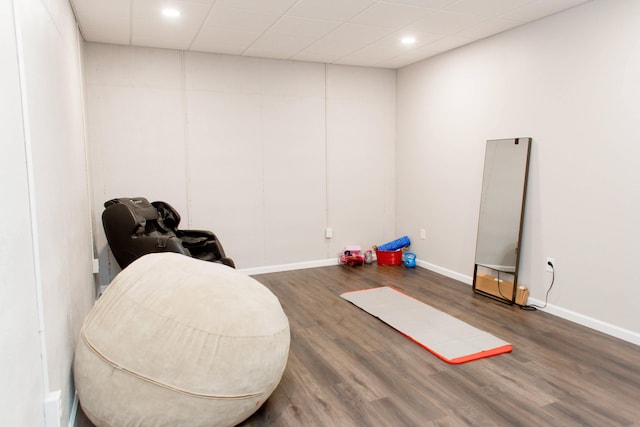 interior space featuring baseboards, wood finished floors, recessed lighting, and a drop ceiling