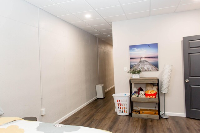 interior space featuring baseboards, wood finished floors, a drop ceiling, and recessed lighting
