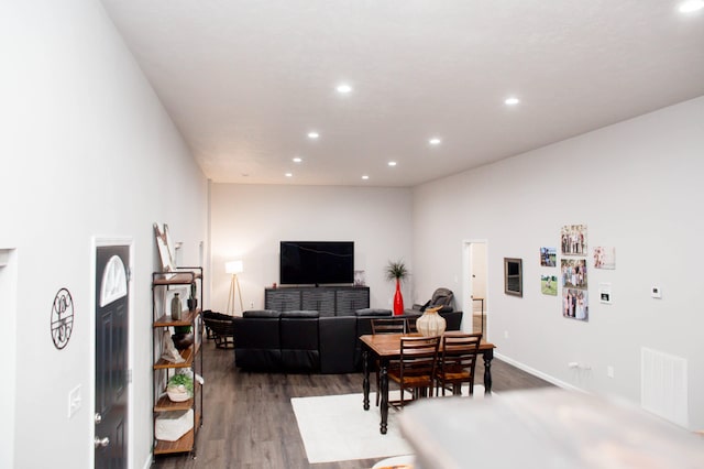 living room featuring dark wood-type flooring, visible vents, and recessed lighting