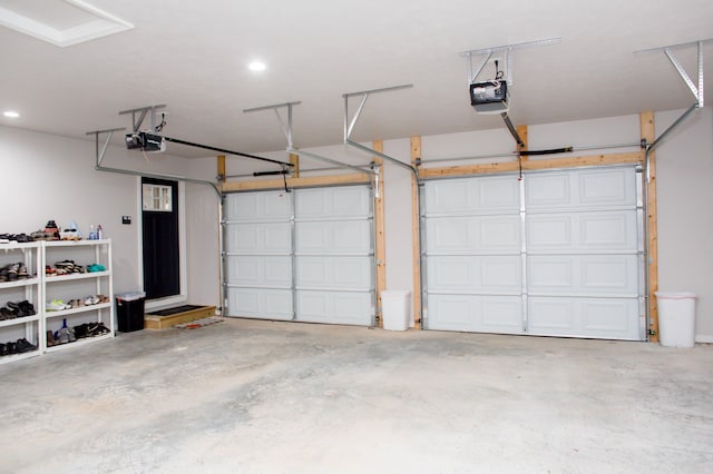 garage with a garage door opener and recessed lighting