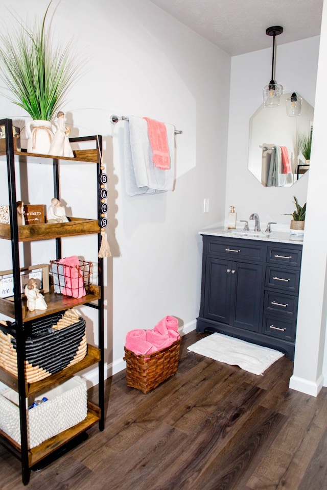 bathroom with baseboards, wood finished floors, and vanity
