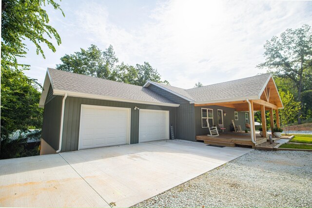 view of front of property featuring an attached garage, a porch, concrete driveway, and a shingled roof