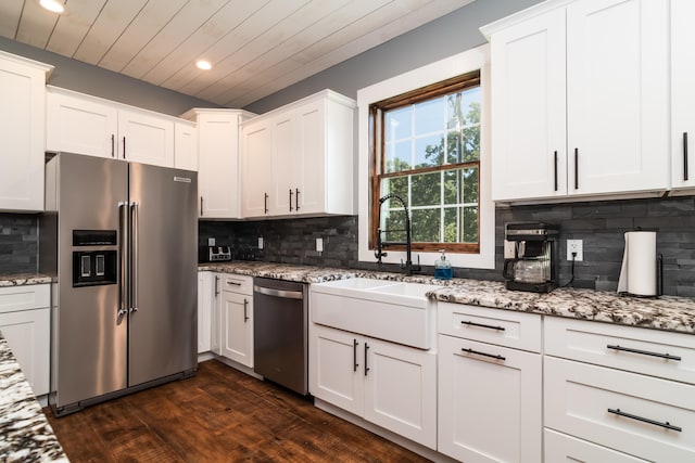 kitchen with decorative backsplash, dark wood-type flooring, sink, stainless steel appliances, and white cabinets