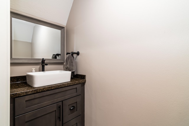 bathroom featuring vaulted ceiling and vanity