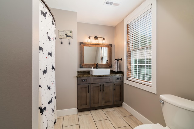 bathroom featuring vanity, toilet, and curtained shower