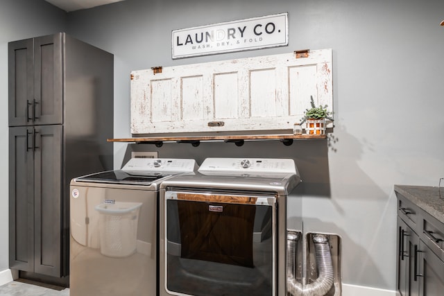 clothes washing area featuring independent washer and dryer and cabinets