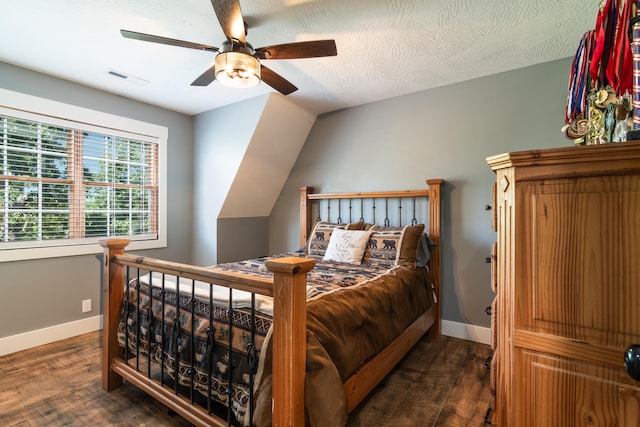 bedroom with lofted ceiling, ceiling fan, dark wood-type flooring, and a textured ceiling