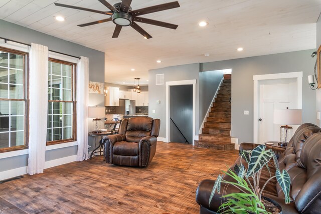 living room featuring ceiling fan and dark wood-type flooring