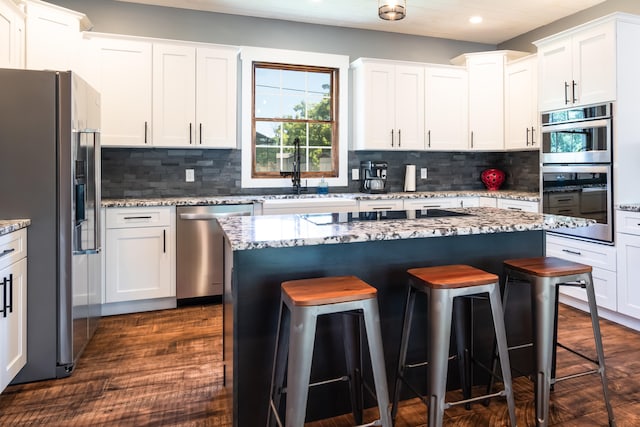 kitchen featuring a kitchen island, white cabinetry, and stainless steel appliances