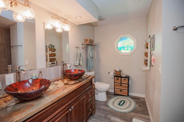 bathroom featuring vanity, toilet, and hardwood / wood-style flooring