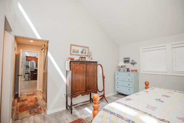 bedroom with high vaulted ceiling and light hardwood / wood-style flooring