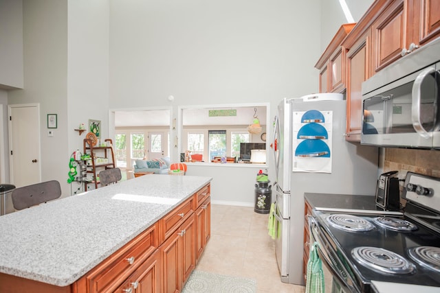 kitchen with light tile patterned flooring, appliances with stainless steel finishes, and a center island