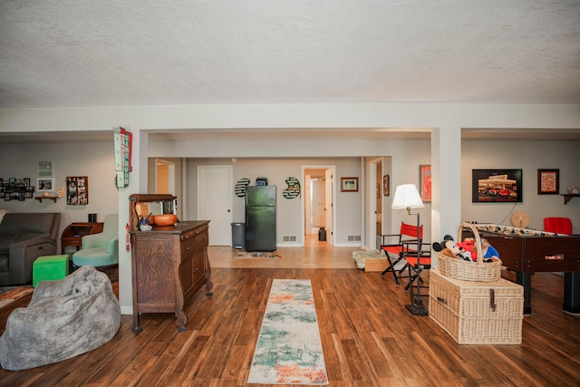 living room featuring dark wood-type flooring and a textured ceiling