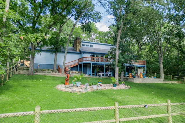 back of house with a lawn and a wooden deck