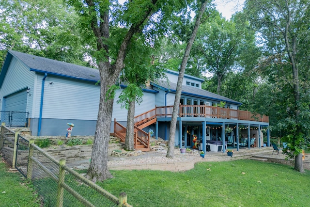 rear view of house featuring a yard and a wooden deck