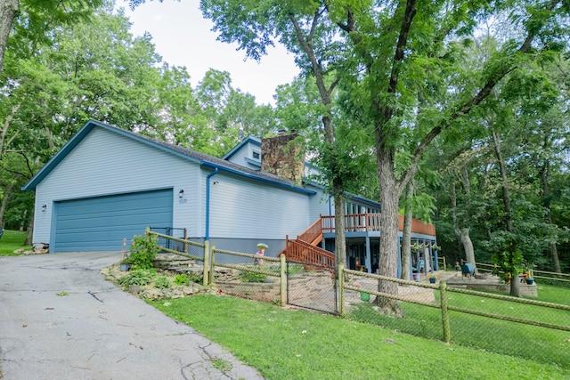 view of front of home with a front yard, a garage, and a deck