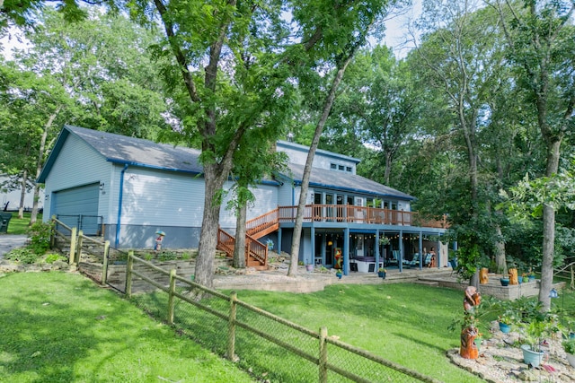 back of property featuring a yard, an outbuilding, a deck, and a garage