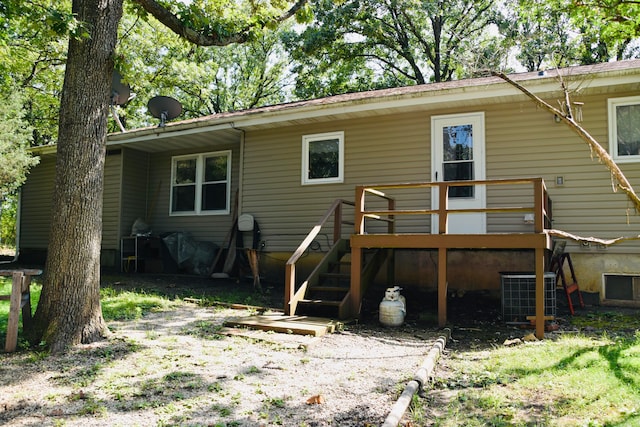 back of house with cooling unit and a deck