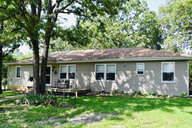 back of property featuring a yard and a deck