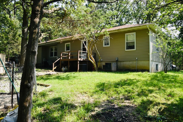 back of property with central AC unit and a yard