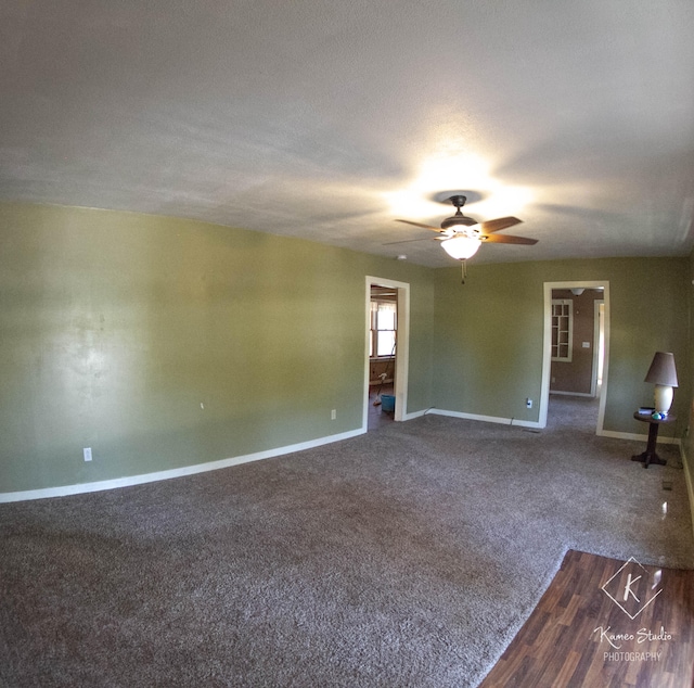 spare room featuring dark wood-type flooring, ceiling fan, and a textured ceiling