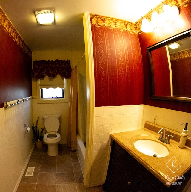 full bathroom with shower / tub combo with curtain, vanity, toilet, and tile walls