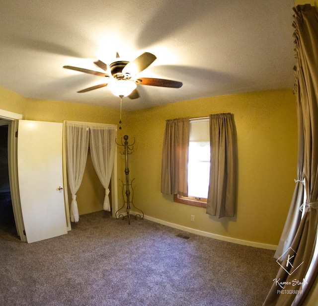 carpeted spare room with a textured ceiling and ceiling fan