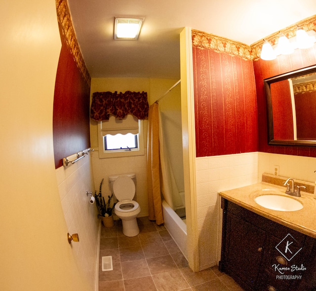 full bathroom with toilet, tile walls, tile patterned flooring, vanity, and shower / bathtub combination with curtain