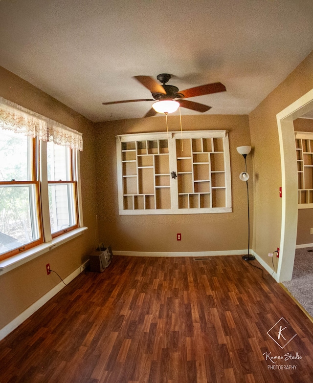 spare room featuring dark hardwood / wood-style flooring, a textured ceiling, and ceiling fan