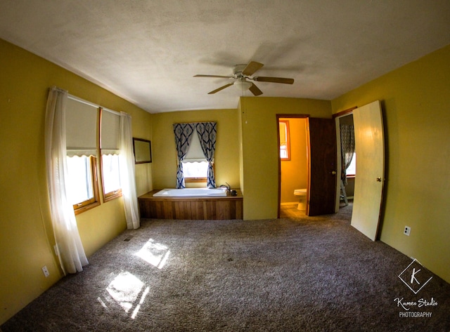 unfurnished bedroom with ceiling fan, ensuite bath, a textured ceiling, and carpet floors