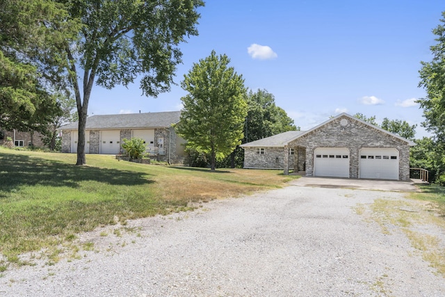 ranch-style home featuring a garage and a front lawn