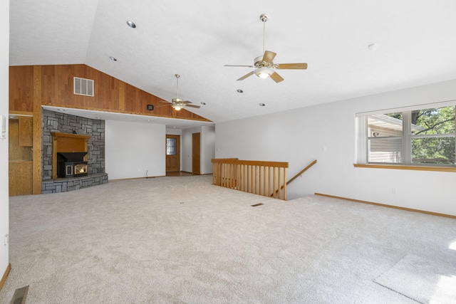 carpeted living room with wood walls, vaulted ceiling, and ceiling fan