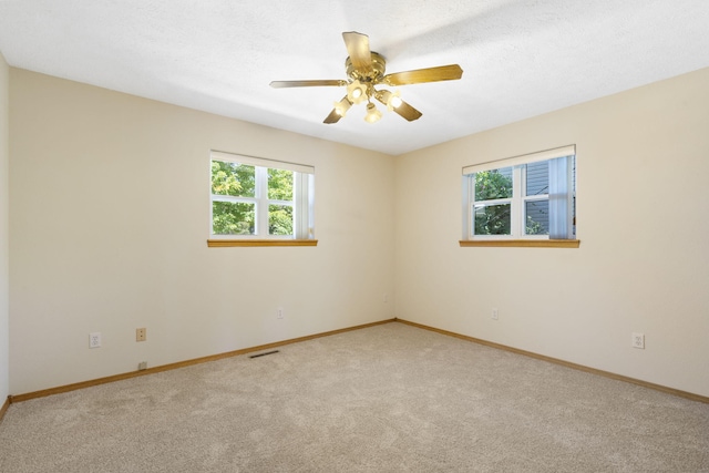 carpeted empty room with a textured ceiling and ceiling fan