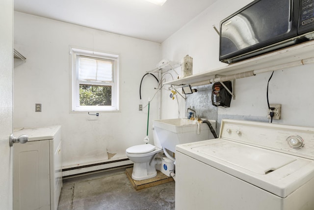 clothes washing area with a baseboard radiator, sink, and washer / dryer