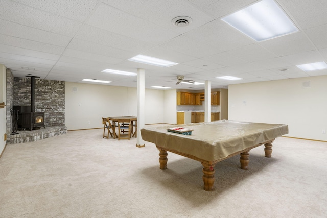 game room featuring light colored carpet, a drop ceiling, pool table, and a wood stove