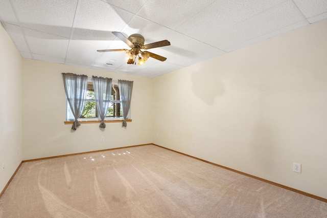 empty room featuring ceiling fan, carpet floors, and a drop ceiling