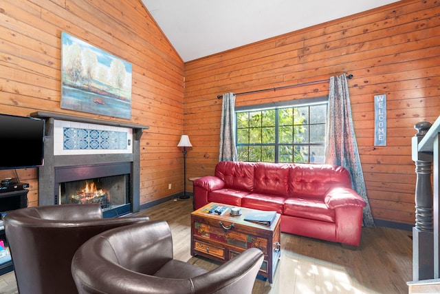 living room with hardwood / wood-style flooring, wood walls, and vaulted ceiling