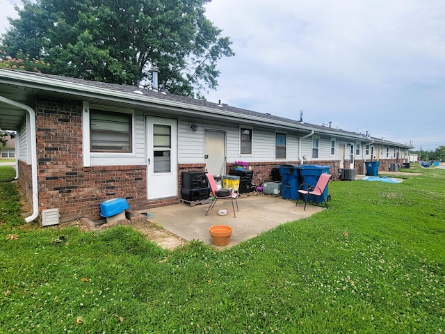 rear view of house featuring central AC, a lawn, and a patio area