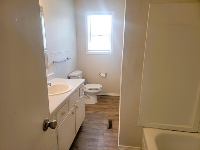 full bathroom with hardwood / wood-style floors, vanity, toilet, and independent shower and bath