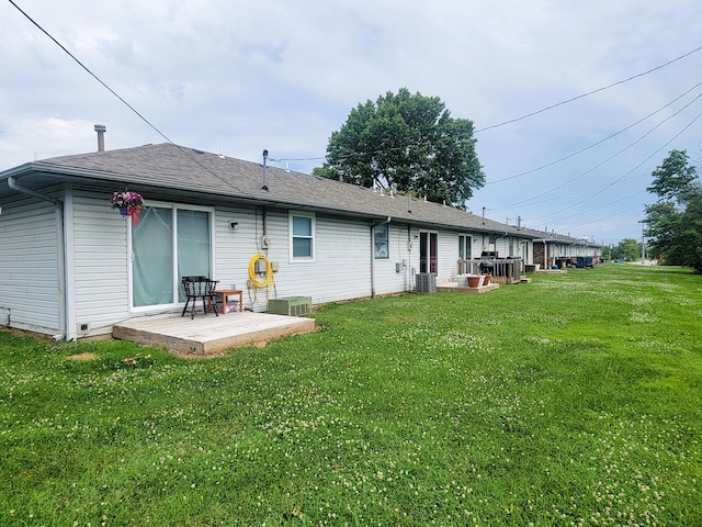 rear view of property with a lawn and central AC