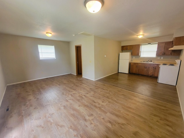 kitchen with white appliances, sink, and light wood-type flooring