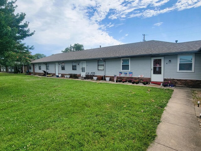 rear view of property with a lawn