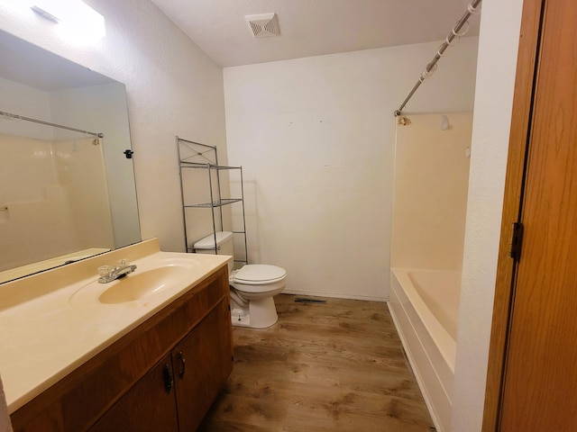 full bathroom featuring wood-type flooring, vanity, toilet, and washtub / shower combination