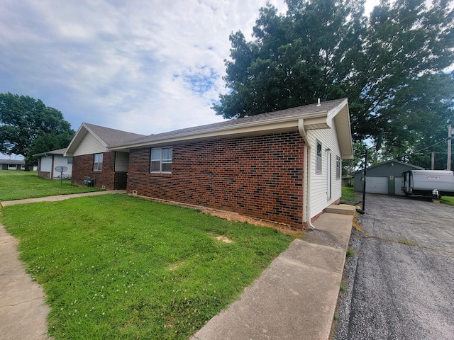 view of front of property featuring an outbuilding, a front lawn, and a garage