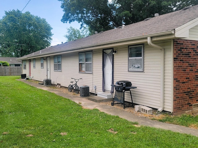 rear view of house with a yard and central air condition unit